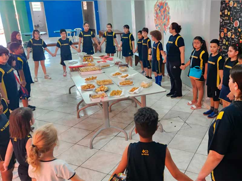 alunos em volta da mesa para comemorar o dia de ação de graças